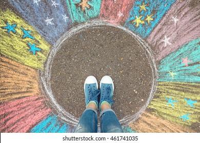 Comfort zone concept. Feet standing inside comfort zone circle surrounded by rainbow stripes painted with chalk on the asphalt. - Shutterstock ID 461741035