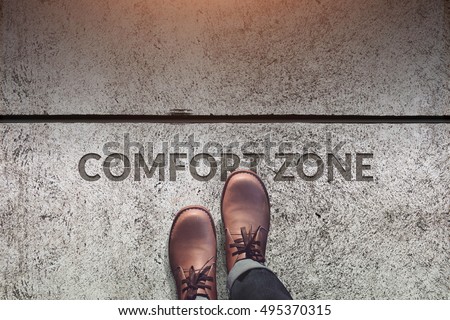 Comfort Zone Concept, Male with Leather Shoes Steps over a word with line on Concrete Floor, Top view