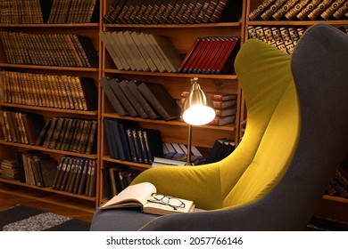 Comfortable Armchair With Book And Glasses In Cozy Home Library