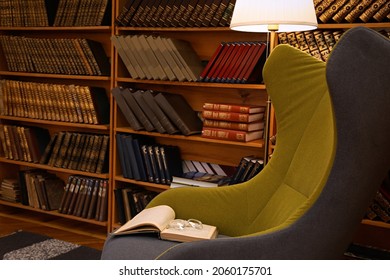 Comfortable Armchair With Book And Glasses In Cozy Home Library