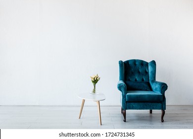 comfortable armchair near tulips on coffee table in living room