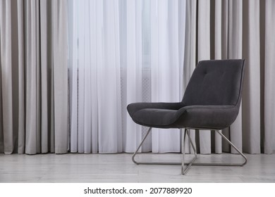 Comfortable armchair near window indoors, space for text. Interior design - Shutterstock ID 2077889920