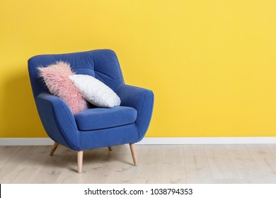 Comfortable Armchair With Soft Pillows Near Color Wall