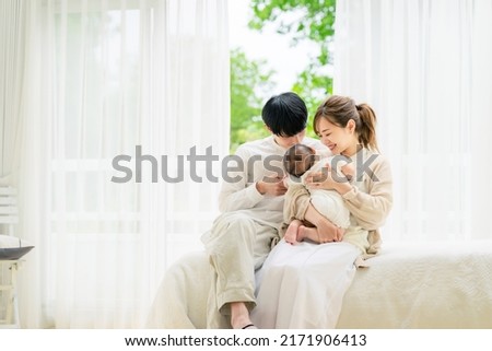 Comfortable Asian young couple and a baby in the house. Child rearing. Newborn.