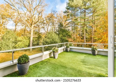 Comfortable Balcony With Artificial Grass And Flower Pots