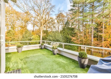 Comfortable Balcony With Artificial Grass And Flower Pots