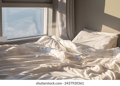 Comfortable bed in front of bright window