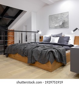 Comfortable Bed On Modern Attic Bedroom On Mezzanine Floor In Loft Style Apartment With Big Window And White Walls