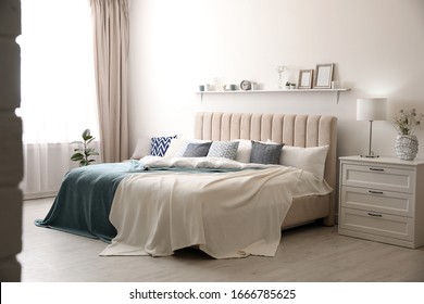 Comfortable bed with pillows in room. Stylish interior design