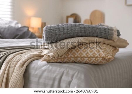 Comfortable bed with soft linens and blankets in room, closeup. Home textile
