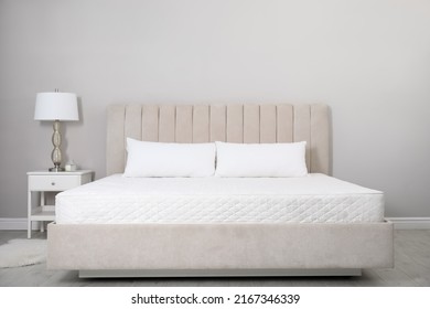 Cómoda cama con colchón blanco suave y almohadas en el interior