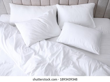Comfortable bed with soft white pillows, closeup