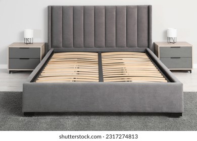 Comfortable bed with storage space for bedding under slatted base in room