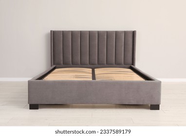 Comfortable bed with storage space for bedding under slatted base in room