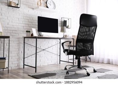 Comfortable chair near desk in modern office interior - Shutterstock ID 1882956094