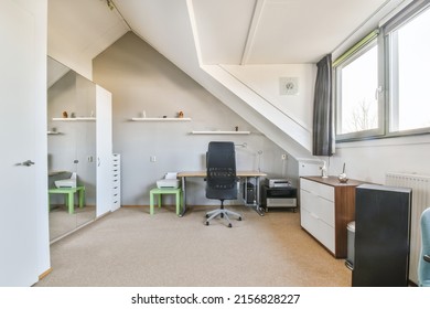 Comfortable Chair Placed Near Table With Computer Monitors Against Blank Whiteboard And Mirror In Light Home Office In Contemporary Flat