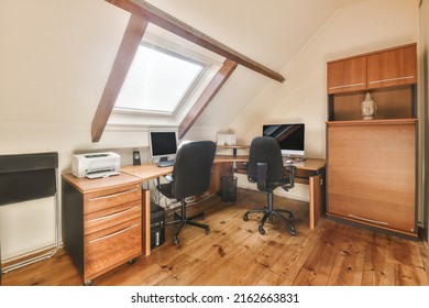 Comfortable Chair Placed Near Table With Computer Monitors Against Blank Whiteboard And Mirror In Light Home Office In Contemporary Flat