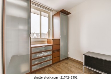 Comfortable Chair Placed Near Table With Computer Monitors Against Blank Whiteboard In Light Home Office In Contemporary Flat