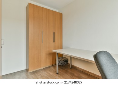 Comfortable Chair Placed Near Table With Computer Monitors Against Blank Whiteboard In Light Home Office In Contemporary Flat