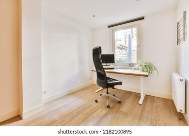 Comfortable Chair Placed Near Table With Computer Monitors Against Blank Whiteboard And Mirror In Light Home Office In Contemporary Flat