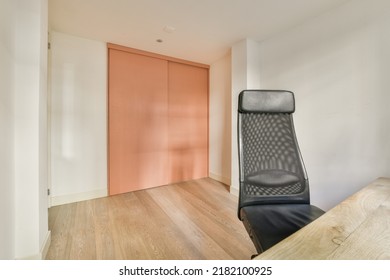 Comfortable Chair Placed Near Table With Computer Monitors Against Blank Whiteboard And Mirror In Light Home Office In Contemporary Flat