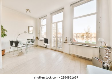 Comfortable Chair Placed Near Table With Computer Monitors Against Blank Whiteboard And Mirror In Light Home Office In Contemporary Flat