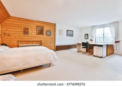 Comfortable Contemporary Bed Located Near Retro Cabinet And Chair In Light Bedroom With Bathroom Doorway At Home