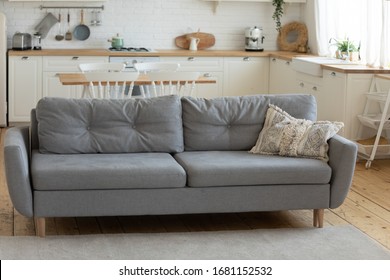 Comfortable Grey Empty Sofa In Center Of Modern Kitchen Or Living Room In Cozy Country House Interior, Gray Comfy Couch Furniture In Shabby Chic Countryside House, Dwelling Renovation And Design