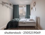 Comfortable guest room with big bed, window with curtains and stylish decorations