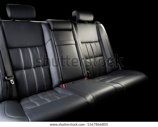 Comfortable leather car seat.\
Black perforarated leather car seat isolated on black background\
with copy space. Comfortable leather car seat. Backseats of the\
modern car