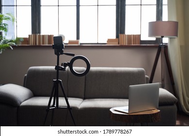 Comfortable Living Room Interior With A Modern Laptop On A Coffee Table And A Ring Light In Front Of A Sofa