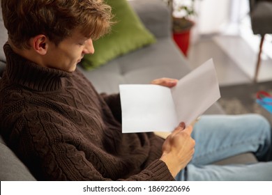 Comfortable. Man Opening, Recieving Greeting Card For New Year And Christmas 2021 From Friends Or Family. Reading A Letter With Best Wishes, Opening Envelope. Holidays, Celebration.