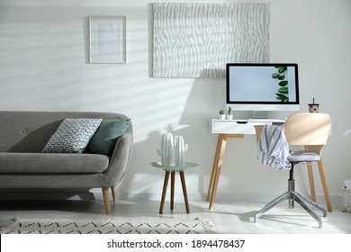 Komfortable Bürostuhl mit Schreibtisch mit modernem Computer im Innenbereich