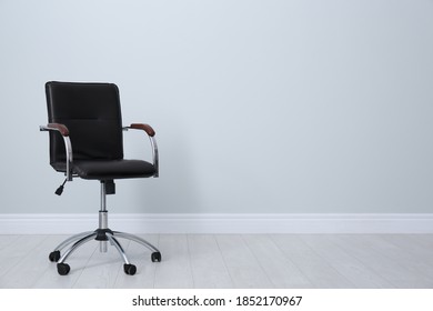 Comfortable Office Chair Near Light Wall Indoors. Space For Text