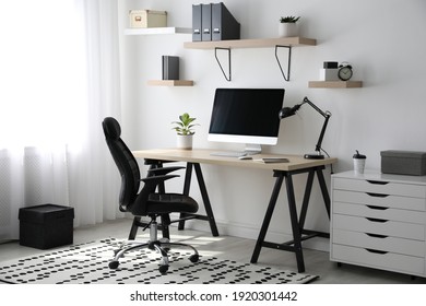 Comfortable office chair near table with modern computer - Shutterstock ID 1920301442