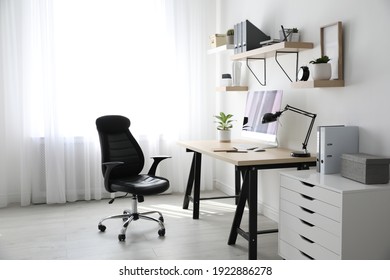 Comfortable office chair near table with modern computer - Shutterstock ID 1922886278