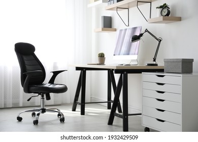 Comfortable office chair near table with modern computer - Shutterstock ID 1932429509