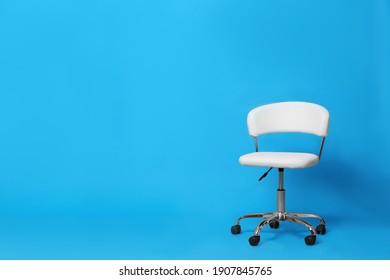 Comfortable office chair on light blue background, space for text