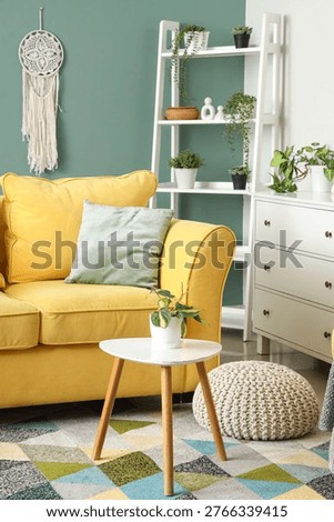 Comfortable sofa, table and shelving unit in interior of living room