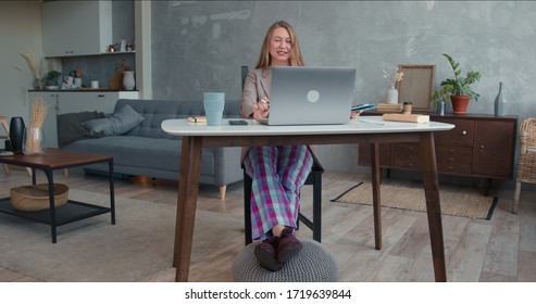 Comfortable Work From Home On Lockdown. Young Cheerful Business Woman In Pajamas Pants Using Laptop Video Conference App