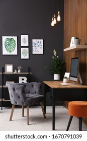 Comfortable Workplace With Computer Near Wooden Wall In Stylish Room Interior. Home Office Design