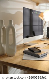 Comfortable workplace with computer and notebooks in home office, closeup