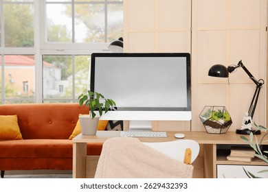 Comfortable workplace with modern computer and folding screen in living room