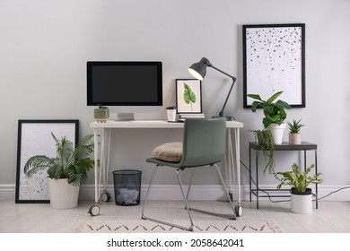 Comfortable Workplace With Modern Computer And Houseplants In Room. Interior Design