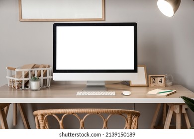 Comfortable workplace with modern computer near grey wall - Shutterstock ID 2139150189