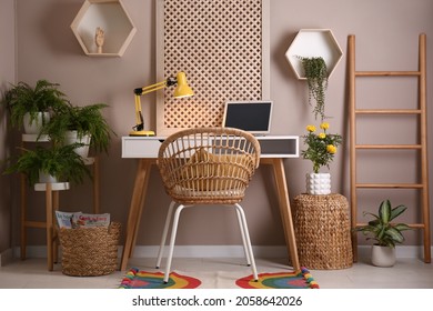 Comfortable workplace with modern laptop and houseplants in room. Interior design - Shutterstock ID 2058642026