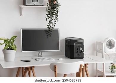 Comfortable workspace with modern computer and portable power station