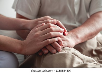 Comforting Hand. Young Nurse Holding Old Man's Hand. Senior Care, Care Taker And Senior Retirement Home Service Concept. Close Up Shot.