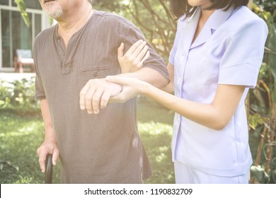 Comforting Hand. Young Nurse Holding Old Man's Shoulder In Outdoor Garden. Senior Care, Care Taker And Senior Retirement Home Service Concept.