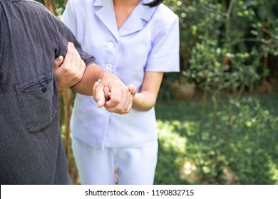 Comforting Hand. Young Nurse Holding Old Man's Shoulder In Outdoor Garden. Senior Care, Care Taker And Senior Retirement Home Service Concept.